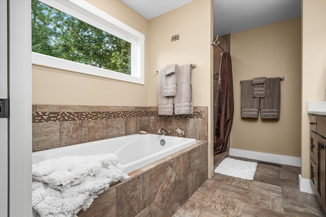 bathroom featuring plus walk in shower and vanity