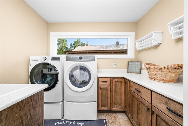 clothes washing area featuring cabinets and washer and dryer