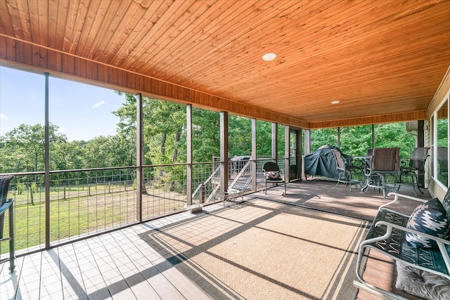 unfurnished sunroom featuring wood ceiling and plenty of natural light