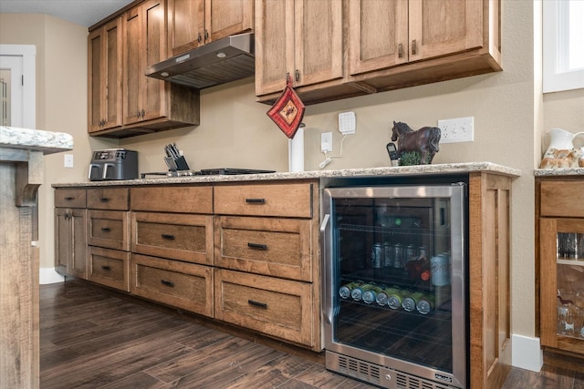 kitchen featuring dark wood-type flooring, beverage cooler, light stone counters, and black gas cooktop