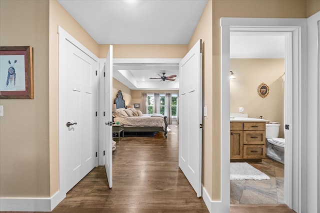 hallway featuring dark hardwood / wood-style flooring and a raised ceiling