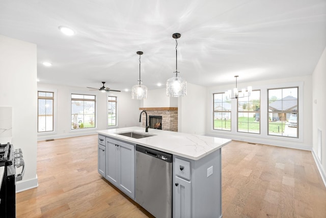 kitchen with open floor plan, stainless steel appliances, a sink, and light wood-style flooring