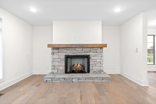 interior details featuring recessed lighting, baseboards, wood finished floors, and a stone fireplace