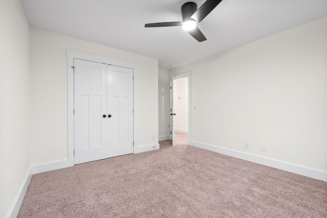 unfurnished bedroom featuring a closet, carpet, a ceiling fan, and baseboards