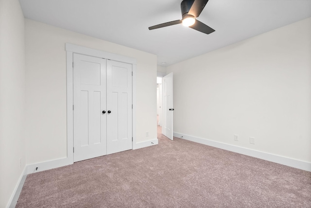 unfurnished bedroom with carpet, a closet, and baseboards