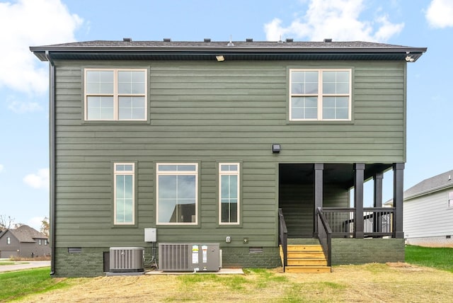 back of house with crawl space, a lawn, and central AC