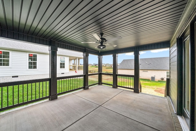 unfurnished sunroom featuring a ceiling fan