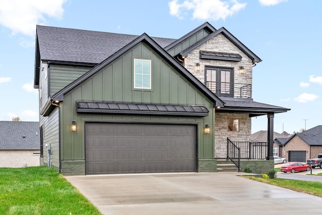 view of front of home with roof with shingles, concrete driveway, board and batten siding, a balcony, and stone siding