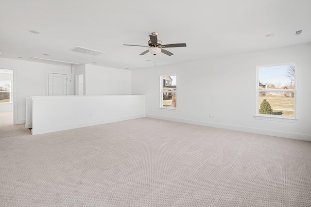 empty room featuring a wealth of natural light and light colored carpet