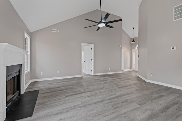 unfurnished living room featuring light hardwood / wood-style flooring, high vaulted ceiling, and ceiling fan