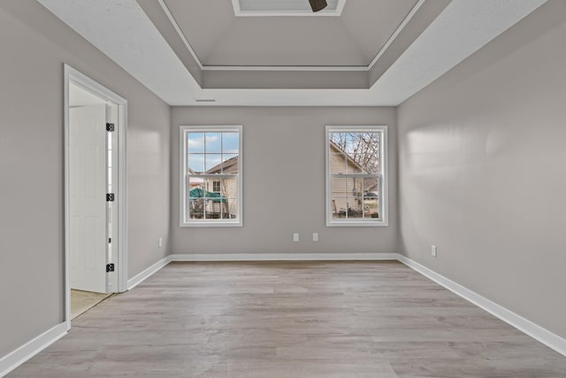 empty room featuring lofted ceiling, a healthy amount of sunlight, and light hardwood / wood-style floors