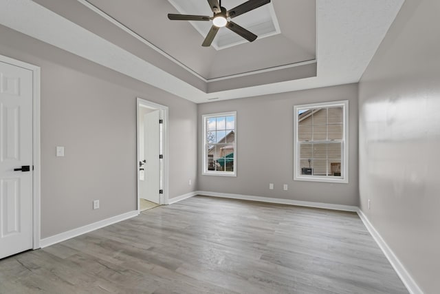 spare room featuring ceiling fan, a raised ceiling, and light hardwood / wood-style floors