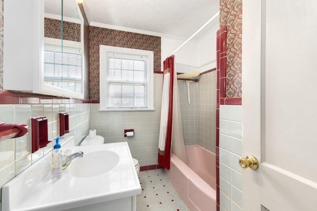 bathroom with sink, tile walls, shower / tub combo, crown molding, and a textured ceiling