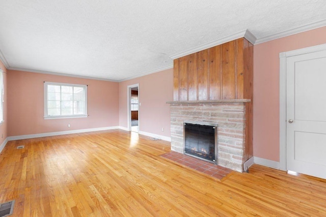 unfurnished living room featuring crown molding, a textured ceiling, and light wood-type flooring