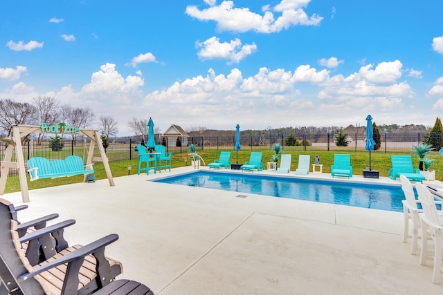 view of pool with a patio and a lawn