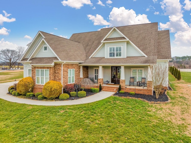 craftsman-style house featuring covered porch and a front lawn