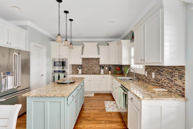 kitchen featuring a kitchen island, white cabinetry, custom exhaust hood, hanging light fixtures, and stainless steel appliances