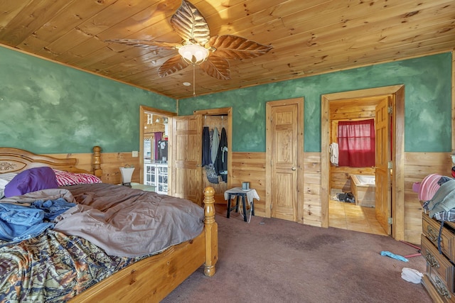 bedroom featuring ceiling fan, carpet floors, wooden walls, and wood ceiling