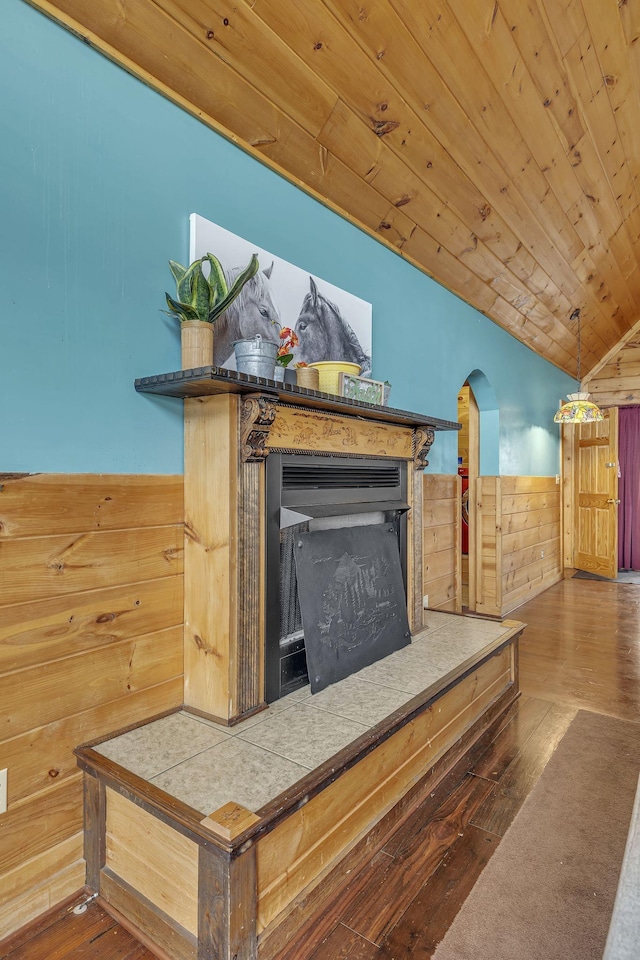 interior details featuring wood walls, a fireplace, hardwood / wood-style floors, and wooden ceiling