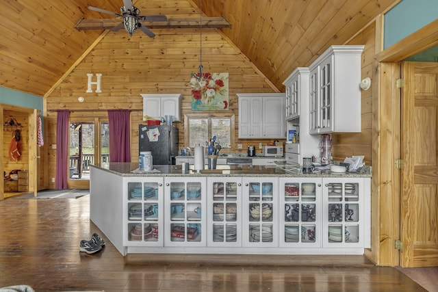 kitchen with black refrigerator, wooden ceiling, stone counters, and white cabinets