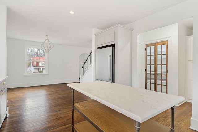 kitchen featuring dark hardwood / wood-style floors, pendant lighting, white cabinetry, a chandelier, and fridge