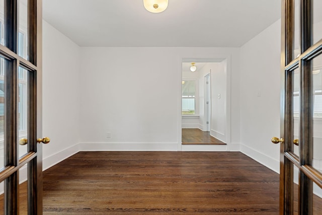 empty room with french doors and dark hardwood / wood-style flooring