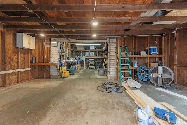 basement with wooden walls and a workshop area