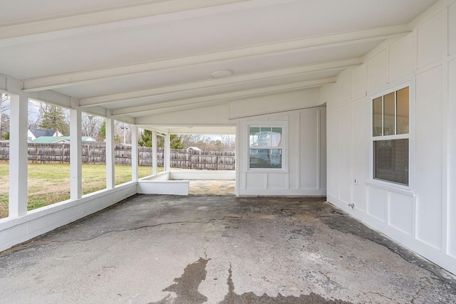 unfurnished sunroom featuring beam ceiling