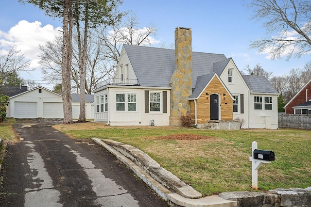 view of front facade featuring an outbuilding, a garage, and a front lawn