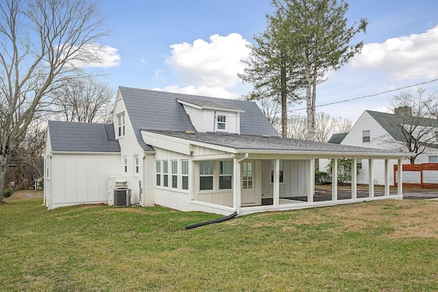 back of property featuring central AC and a lawn