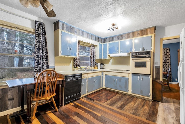 kitchen with blue cabinets, a textured ceiling, dark hardwood / wood-style flooring, and black appliances