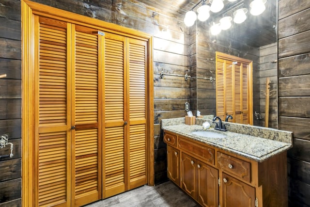 bathroom featuring vanity and wood walls