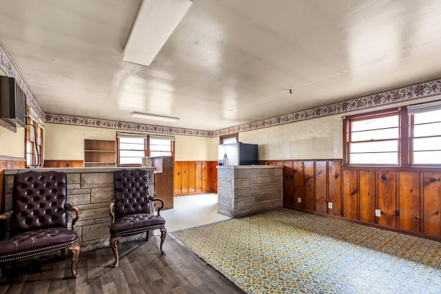 sitting room featuring wood-type flooring and wood walls