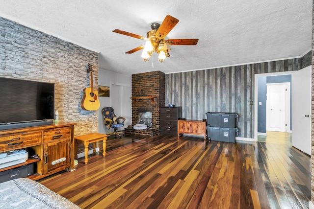 living room with ceiling fan, a textured ceiling, and dark hardwood / wood-style flooring