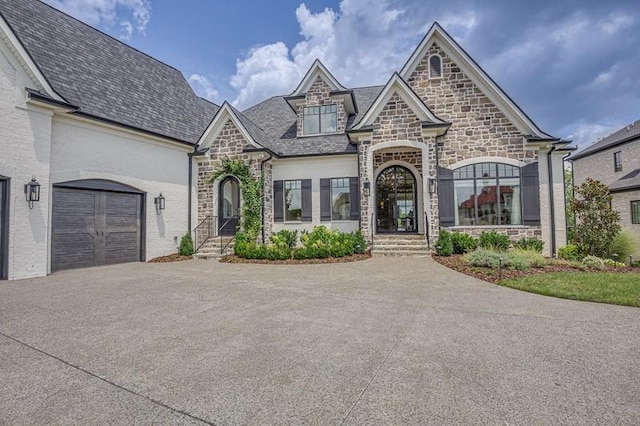 french country style house with a garage