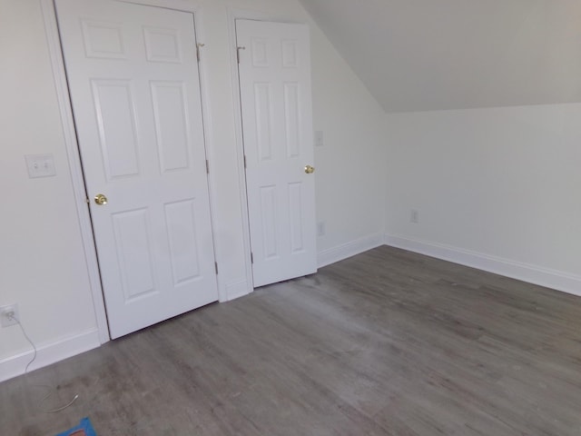 bonus room with lofted ceiling and dark hardwood / wood-style floors