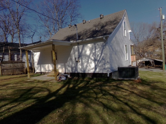 rear view of property with central AC, a patio area, and a lawn