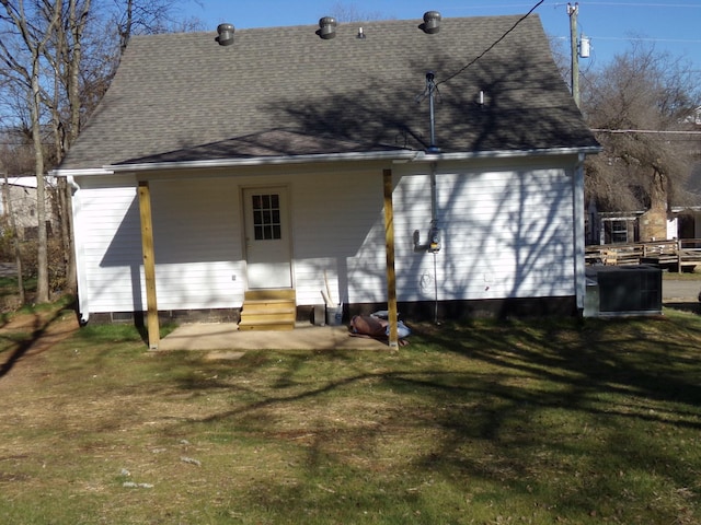 rear view of property featuring a lawn