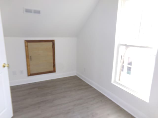 bonus room with hardwood / wood-style flooring and vaulted ceiling