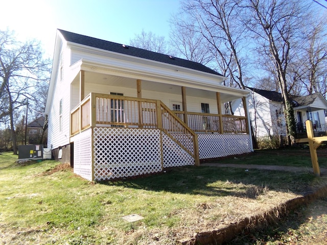 back of house featuring a yard and covered porch