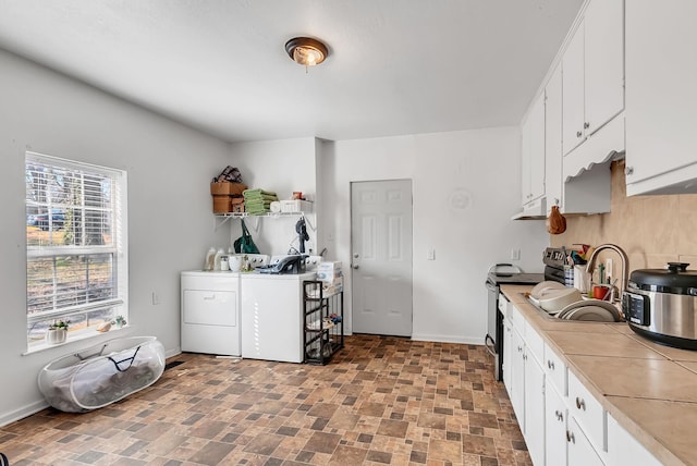 kitchen featuring separate washer and dryer, sink, white cabinets, and stainless steel electric range