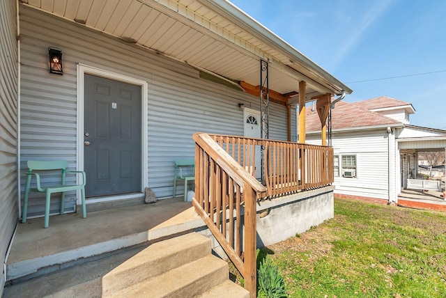 doorway to property featuring a porch and a lawn