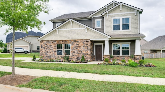 craftsman house with a garage and a front lawn