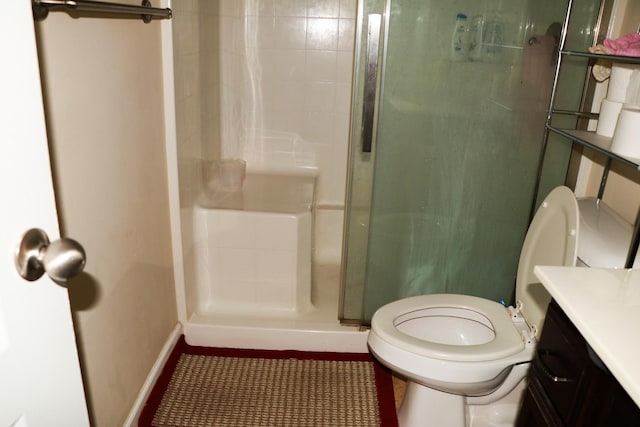 bathroom with vanity, toilet, and tiled shower