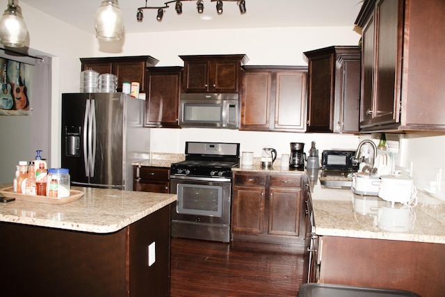 kitchen featuring dark hardwood / wood-style flooring, hanging light fixtures, stainless steel appliances, and dark brown cabinetry