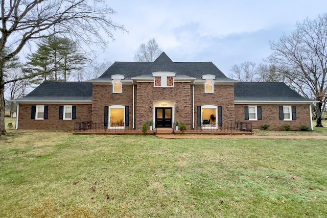 view of front of house featuring a front lawn, french doors, and brick siding