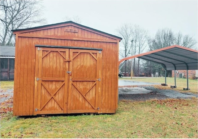 view of outdoor structure with a lawn and a carport