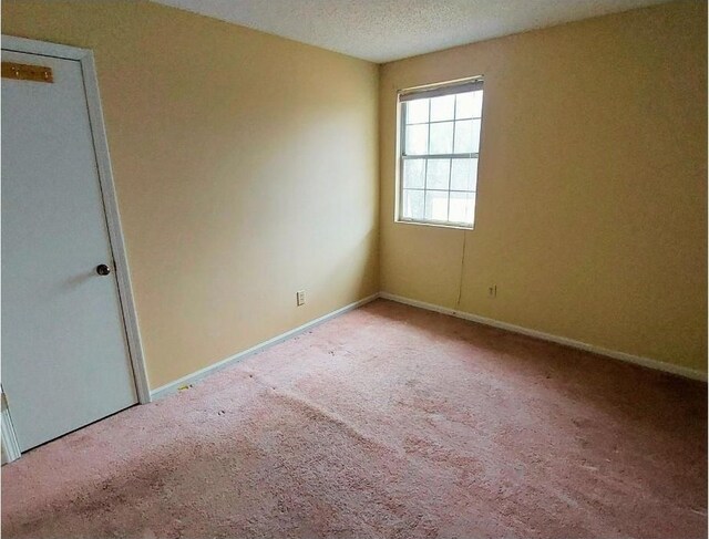 carpeted spare room featuring a textured ceiling