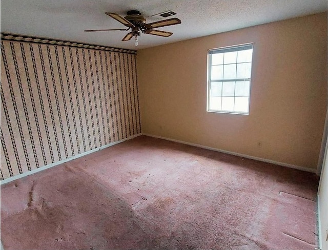 empty room featuring ceiling fan, carpet floors, and a textured ceiling