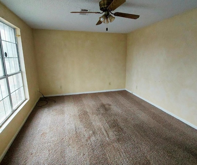 empty room featuring carpet floors, a textured ceiling, and ceiling fan